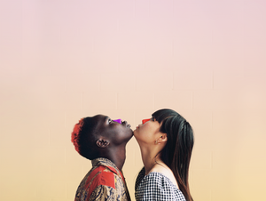 A man and women looking up while wearing purple and orange Nöz mineral sunscreen on their noses.
