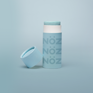 A blue Nöz sunscreen stick in sustainable cardboard packaging. The stick is mineral sunscreen that is reef-safe, waterproof and dermatologist recommended.
