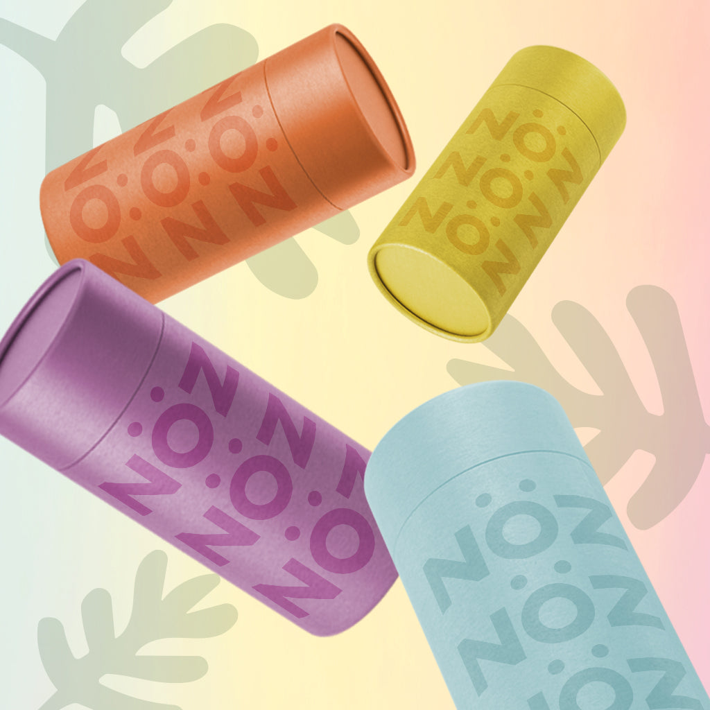 4 sticks of Nöz's colorful mineral sunscreen sticks  oriented at various angles in the colors blue, yellow, orange and purple.